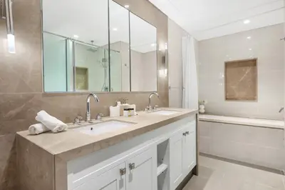 a bathroom with a sink and a large mirror at Luxury 3BR with Burj Khalifa Views, Pool, Gym, and Free Parking in Dubai