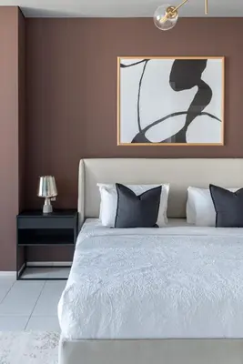 a bedroom with a bed and a painting on the wall at Silkhaus contemporary 1BDR with Downtown view in DIFC in Dubai