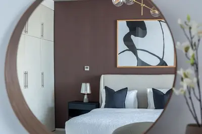 a bedroom with a white bed and a mirror at Silkhaus contemporary 1BDR with Downtown view in DIFC in Dubai