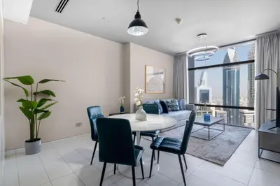 a living room with a table and chairs and a couch at Silkhaus contemporary 1BDR with Downtown view in DIFC in Dubai