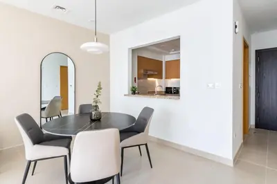 a dining room with a black table and chairs at Silkhaus unique 1BDR pad gorgeous view in new tower in Dubai