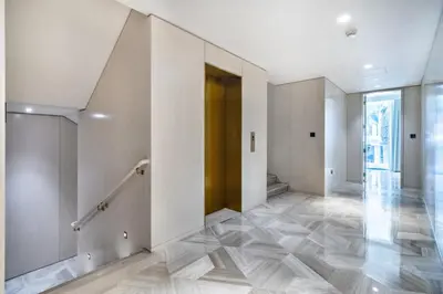 a hallway with white walls and tile floors and a brown door at FIVE Palm Beachfront Villa -Private Pool & Jacuzzi, Panoramic Views, by Exclusive Holiday Homes in Dubai