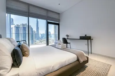 a bedroom with a large bed and a large window at Maison Privee - Luxury Apt with Burj Khalifa Vw & Dubai Canal Access in Dubai