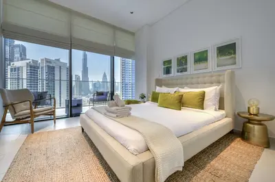 a bedroom with a large bed and a large window at Maison Privee - Luxury Apt with Burj Khalifa Vw & Dubai Canal Access in Dubai