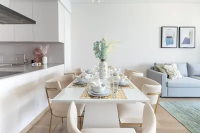 a white dining room with a white table and chairs at Frank Porter - The Address JBR in Dubai