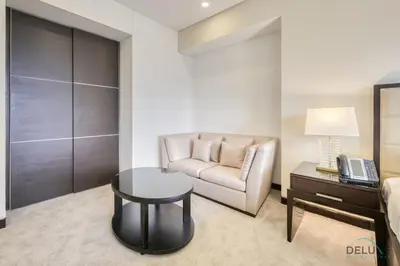 a living room with a couch and a table and a chair at Steps Away From Marina Mall with Iconic Marina Canal Views, The Address Residences, Dubai Marina by Deluxe Holiday Homes in Dubai