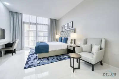 a bedroom with a bed and a chair and a desk at Superb Studio at Damac Celestia A Dubai South By Deluxe Holiday Homes in Dubai