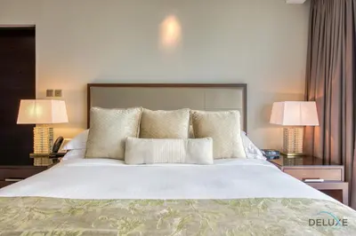 a bedroom with a large white bed with two lamps at Marina Gem with Overlooking Canal Views 1BR Next to Mall, The Address Residences, Dubai Marina by Deluxe Holiday Homes in Dubai