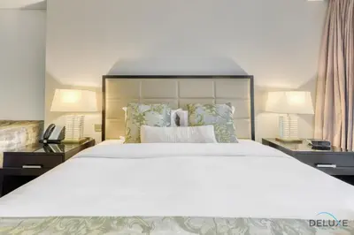 a bedroom with a large white bed with two lamps at Regal Studio at The Address Residences Dubai Marina by Deluxe Holiday Homes in Dubai