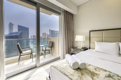 a bedroom with a bed and a balcony with a table at Upscale Studio at The Address Residences Dubai Marina by Deluxe Holiday Homes in Dubai