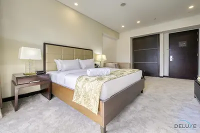 a bedroom with a large bed and a table with a lamp at Upscale Studio at The Address Residences Dubai Marina by Deluxe Holiday Homes in Dubai