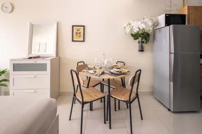 a dining room with a table with chairs and a refrigerator at Frank Porter - Elite Sports Residence in Dubai