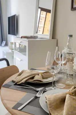 a table with a plate of food and wine glasses at Frank Porter - Elite Sports Residence in Dubai