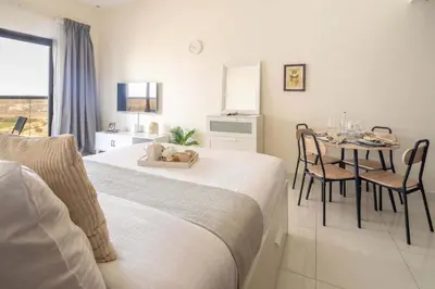 a bedroom with a bed and a table with chairs at Frank Porter - Elite Sports Residence in Dubai
