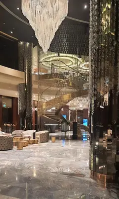 a large lobby with a large chandelier in a hotel at Quill Residence at Paramount Towers 3 BR Creek View in Dubai