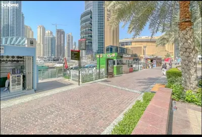 a city street with a palm tree and buildings at Dubai marina sail in Dubai
