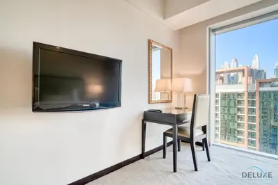 a room with a desk and a large flat screen tv at Pristine 1BR in The Address Residences Dubai Marina by Deluxe Holiday Homes in Dubai