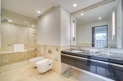 a bathroom with a toilet and a sink and a mirror at Pristine 1BR in The Address Residences Dubai Marina by Deluxe Holiday Homes in Dubai