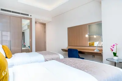 a hotel room with two beds and a desk at GlobalStay DAMAC Towers by Paramount Business Bay Apartments in Dubai