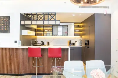 a kitchen with red chairs and a glass table at Designer apartment on the Marina Walk in Dubai