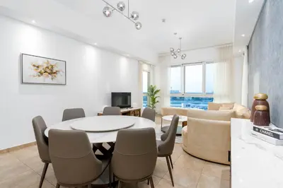 a living room with a table and chairs at Ahlan HH - Luxurious Apartment with Beach Access and Sea View at Palm Jumeirah in Dubai