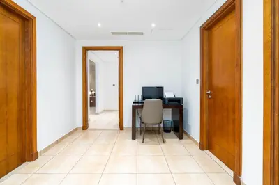 a hallway with a desk with a computer and a chair at Ahlan HH - Luxurious Apartment with Beach Access and Sea View at Palm Jumeirah in Dubai