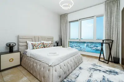 a bedroom with a large bed and a large window at Ahlan HH - Luxurious Apartment with Beach Access and Sea View at Palm Jumeirah in Dubai