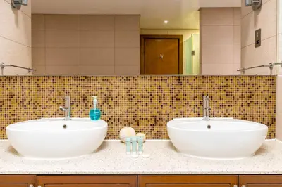 two white sinks in a bathroom with a mirror at Ahlan HH - Luxurious Apartment with Beach Access and Sea View at Palm Jumeirah in Dubai