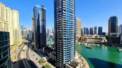 a tall building next to a river in a city at Marco Polo - Experience beachfront luxury at Bahar 6 JBR in Dubai