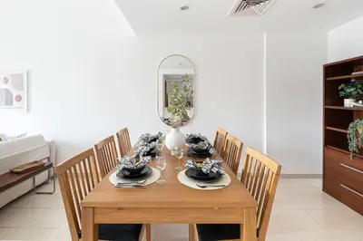 a dining room table with chairs and a mirror at Frank Porter - Al Samar in Dubai