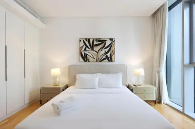 a bedroom with a large white bed with two lamps at Livbnb - Tranquil 2BR in Bluewaters in Dubai