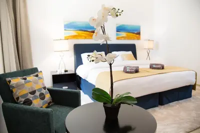 a hotel room with a bed and a table with a flower at HiGuests - Charming Apt in JBR with Balcony by the Beach in Dubai
