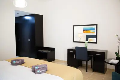 a bedroom with a bed and a desk and a chair at HiGuests - Charming Apt in JBR with Balcony by the Beach in Dubai