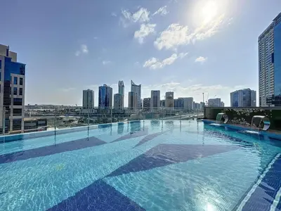 a large swimming pool with a city skyline in the background at White Sage - Elite Residence Studio in Dubai