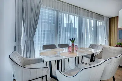 a dining room with a table and chairs and a large window at Luxury 2BD apartment in MarinaGate Jumeirah Living in Dubai