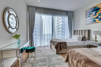 a hotel room with two beds and a window at Luxury 2BD apartment in MarinaGate Jumeirah Living in Dubai