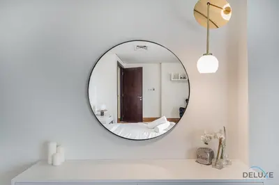 a bathroom with a mirror on a white wall at Refreshing 1BR Loft At Sky Garden DIFC By Deluxe Holiday Homes in Dubai