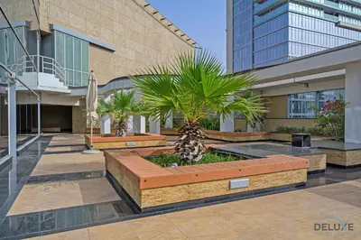 a courtyard with palm trees and a building at Refreshing 1BR Loft At Sky Garden DIFC By Deluxe Holiday Homes in Dubai