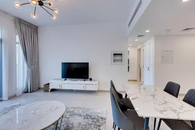 a living room with a table and chairs and a tv at Luxury 1BD apartment in Madinat Jumeirah Living in Dubai