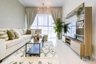 a living room with a white couch and a table at Prime 1BR at Carson B DAMAC Hills Dubailand by Deluxe Holiday Homes in Dubai