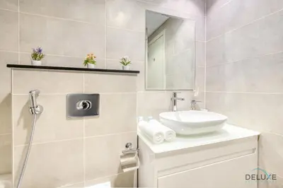 a bathroom with a sink and a mirror at Prime 1BR at Carson B DAMAC Hills Dubailand by Deluxe Holiday Homes in Dubai