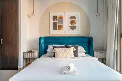 a bed with a blue headboard in a bedroom at GuestReady - Luxury Tower with Burj Khalifa View in Dubai