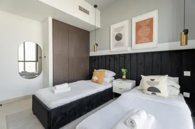 a bedroom with two beds and a mirror at GuestReady - Luxury Tower with Burj Khalifa View in Dubai