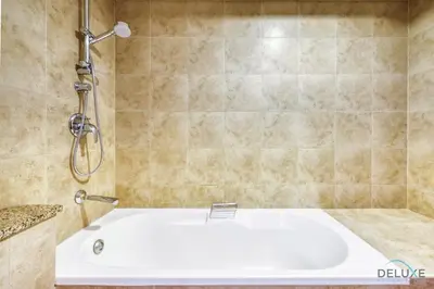 a bath tub in a bathroom with a shower at Calm Studio at Sky Gardens DIFC by Deluxe Holiday Homes in Dubai