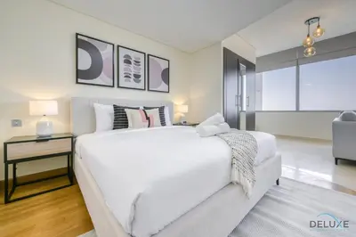 a bedroom with a large white bed and a table at Calm Studio at Sky Gardens DIFC by Deluxe Holiday Homes in Dubai