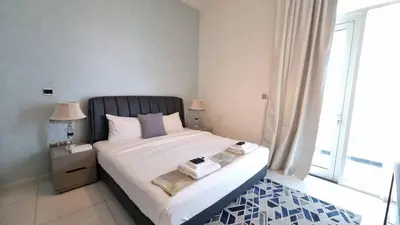 a bedroom with a large bed with a large window at Spacious, Economical Apt Near Miralcz Garden in Dubai