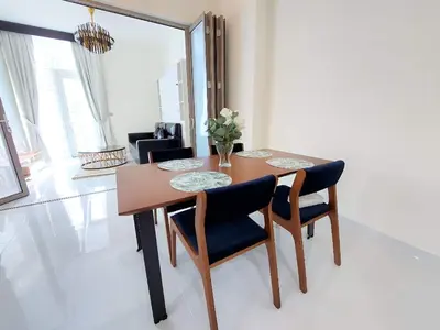 a dining room table with two chairs and a mirror at Spacious, Economical Apt Near Miralcz Garden in Dubai