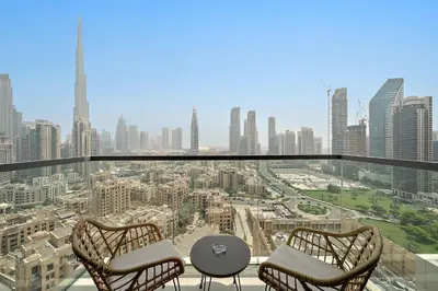 a balcony with two chairs and a table and a city at Silkhaus Burj Khalifa view large 2BDR in great location in Dubai