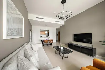 a living room with a white couch and a tv at Silkhaus Burj Khalifa view large 2BDR in great location in Dubai