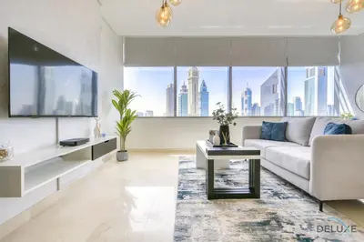 a living room with a couch and a tv at Welcoming Studio at Sky Gardens DIFC By Deluxe Holiday Homes in Dubai
